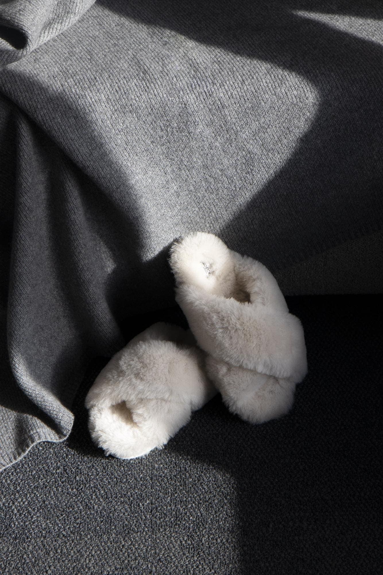 Beige slippers Cinta made of cozy lambskin keep your feet nice and warm.