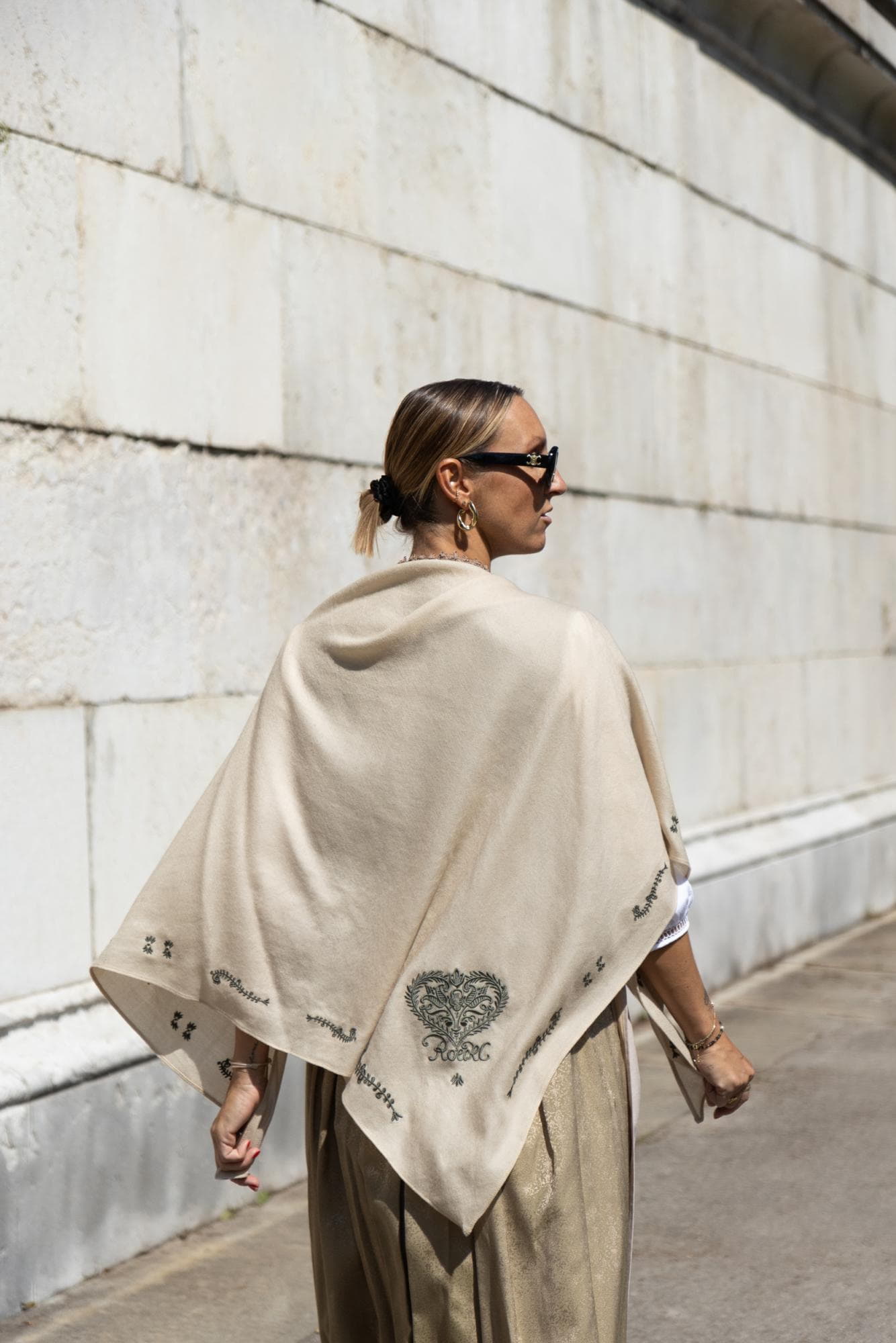 Frau trägt beiges ROECKL-Schultertuch mit Herzmotiv – luxuriöses Wolltuch mit Stickerei als elegantes Trachten-Accessoire.