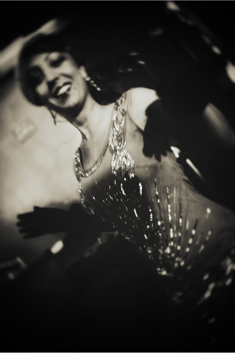 Frau in glitzerndem Abendkleid mit langen Handschuhen – glamouröse Darstellung zeitloser ROECKL-Eleganz im Retro-Stil.