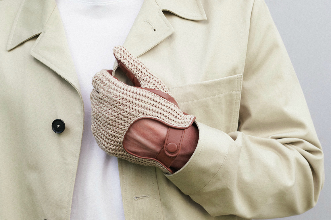 Nahaufnahme eines Herren mit gehäkelten Autofahrerhandschuhen.