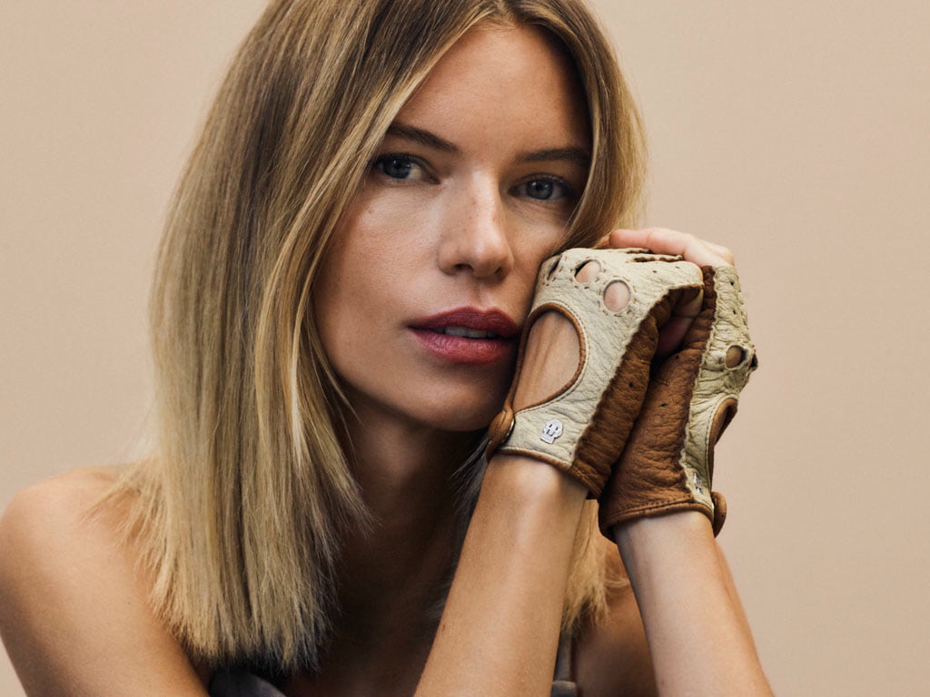 Frau trägt beige-braune ROECKL-Fahrerhandschuhe aus feinem Leder – elegantes Accessoire im modernen, stilbewussten Look.