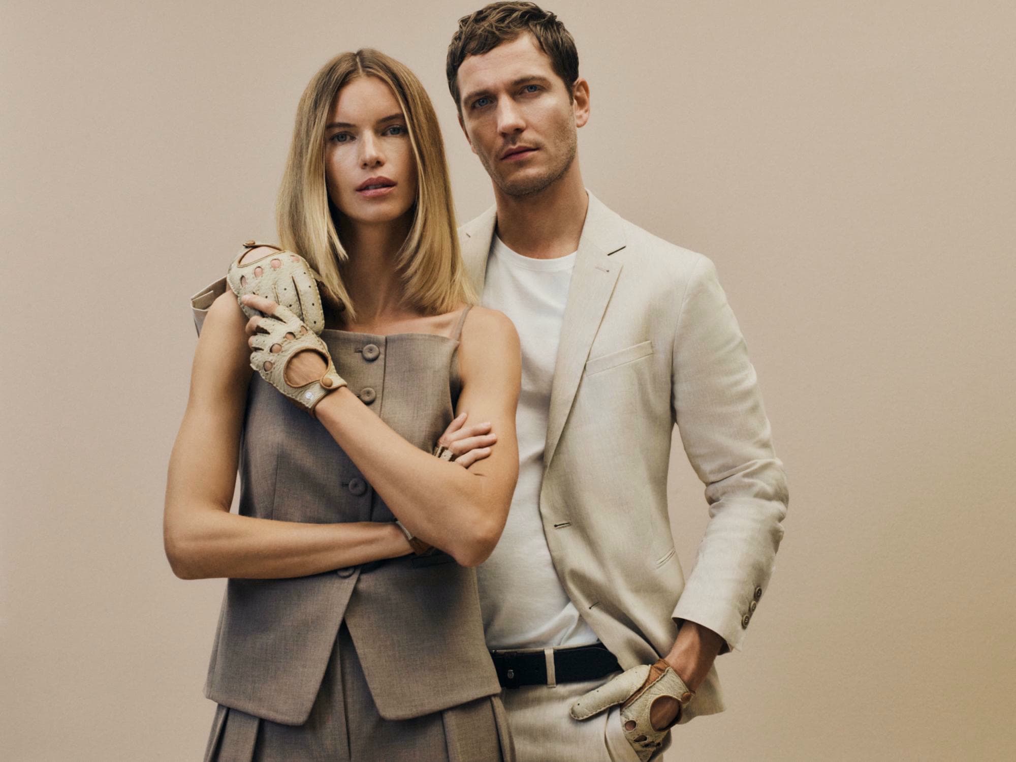 Ein Mann und eine junge Dame tragen helle Kleidung und passende Autofahrerhandschuhe in hellem Peccary Leder.