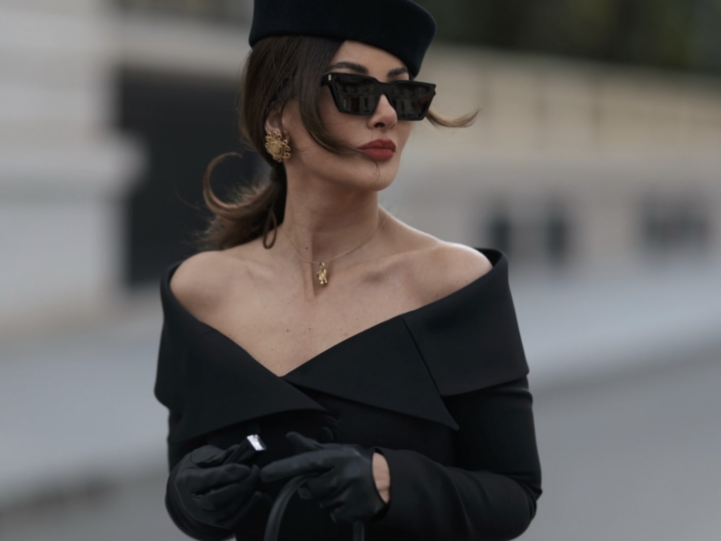 Eine Dame trägt dünne Lederhandschuhe in schwarz, passend zu einem schwarzen Outfit