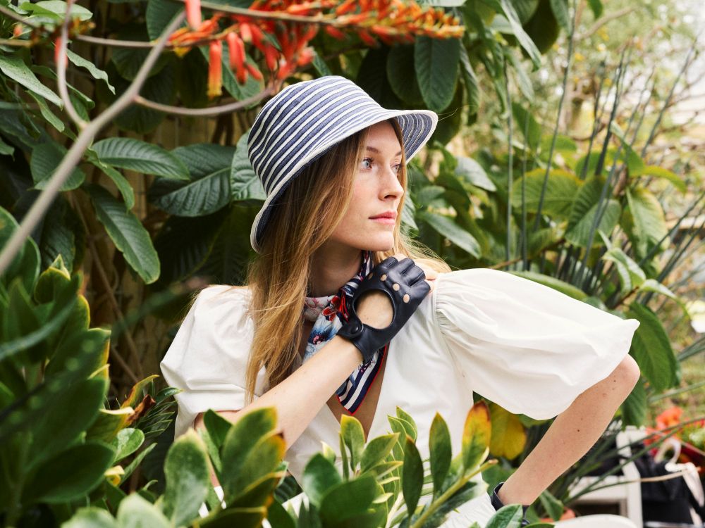 Frau trägt gestreiften ROECKL-Sonnenhut in Schwarz und Natur – stilvoller Hut mit weiter Krempe und modernem Streifendesign.