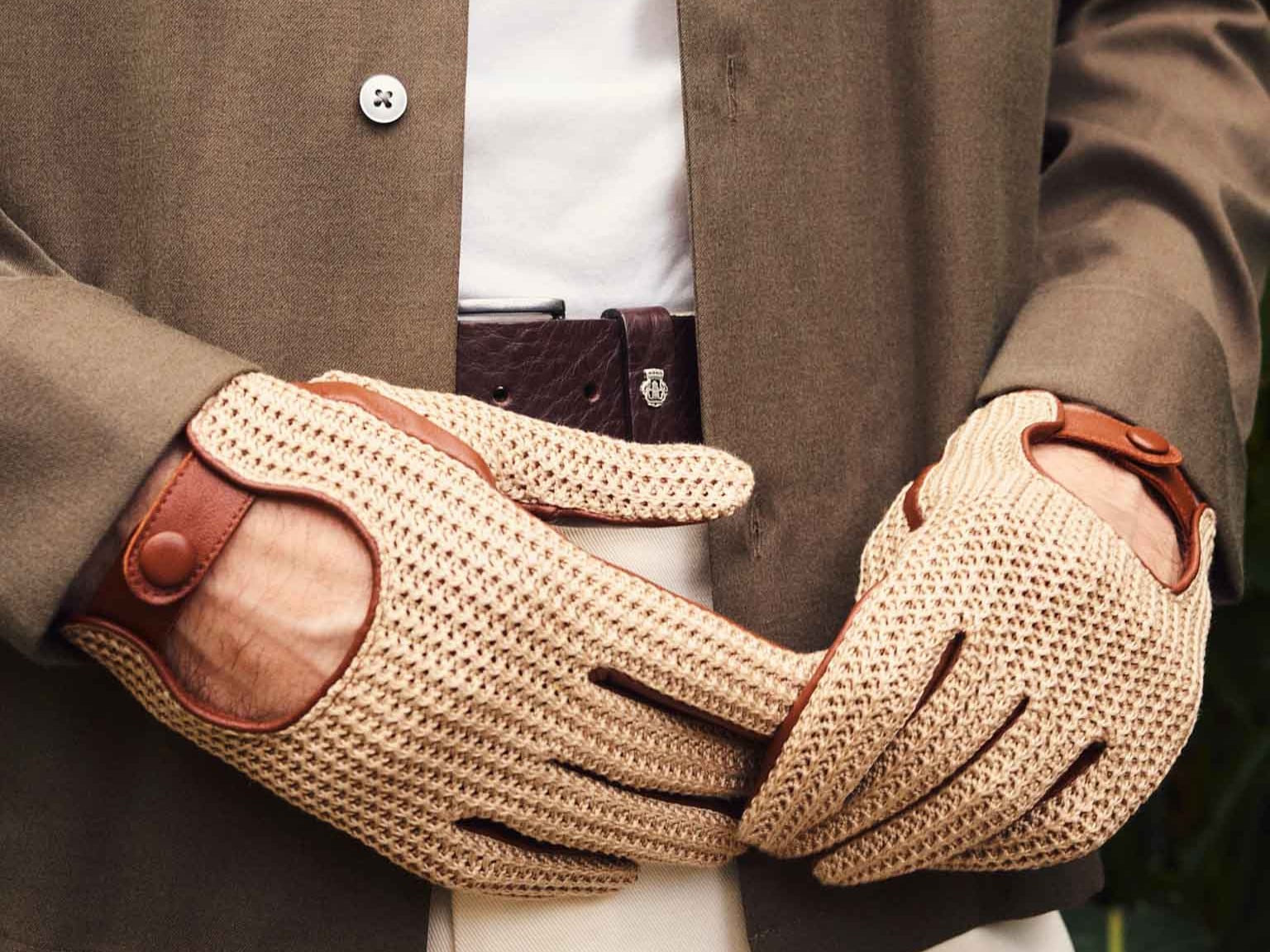 Mann mit dunkelgrüner Jacke und beigen ROECKL-Fahrerhandschuhen aus Leder und Häkelgeflecht – stilvolles Accessoire für einen eleganten, sportlichen Look.
