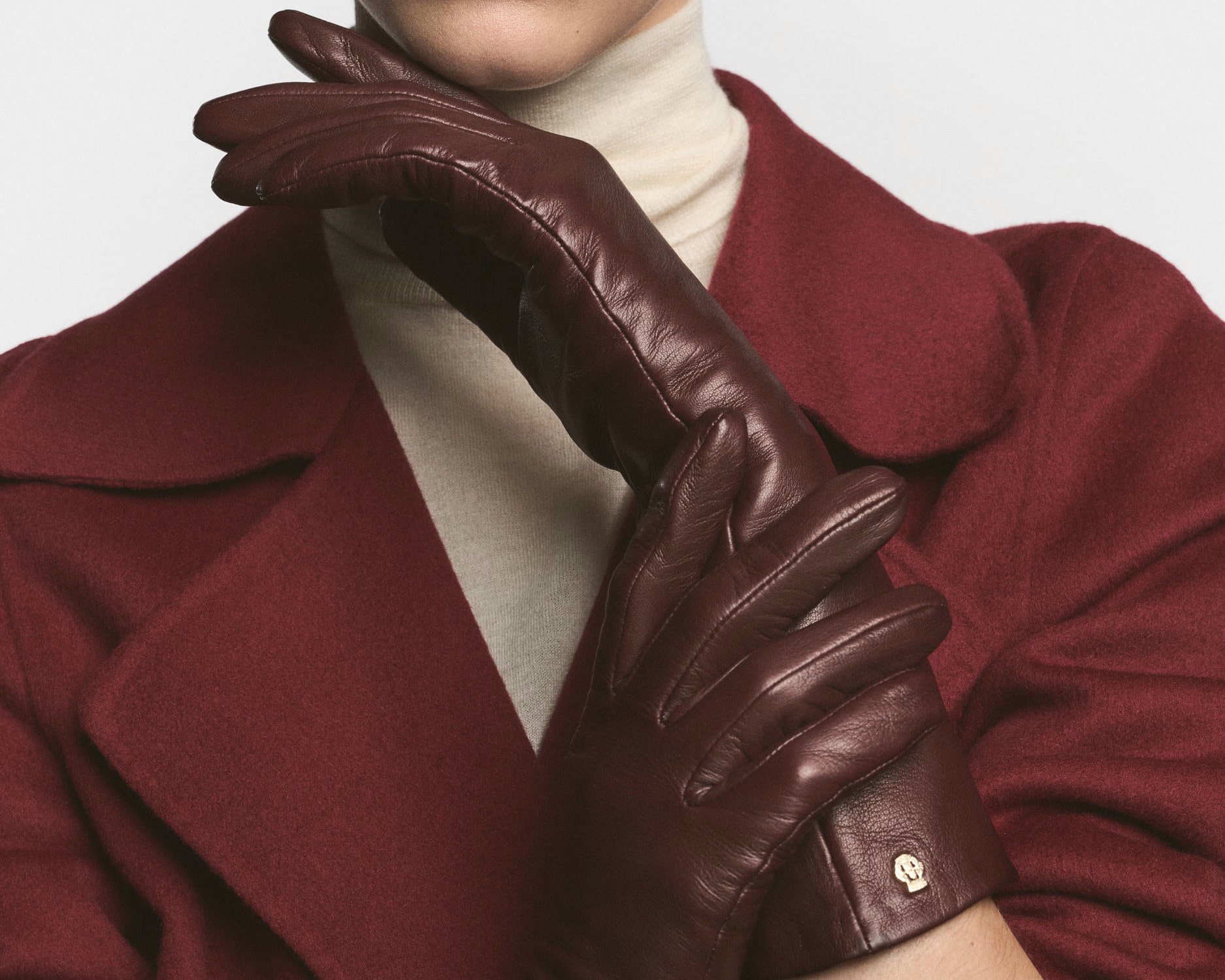 Dame mit braunem Haar trägt hellrosa Lederhandschuhe