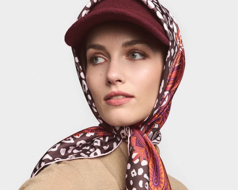 Dame trägt eine rote Filzpappe und eine rote Jacke.