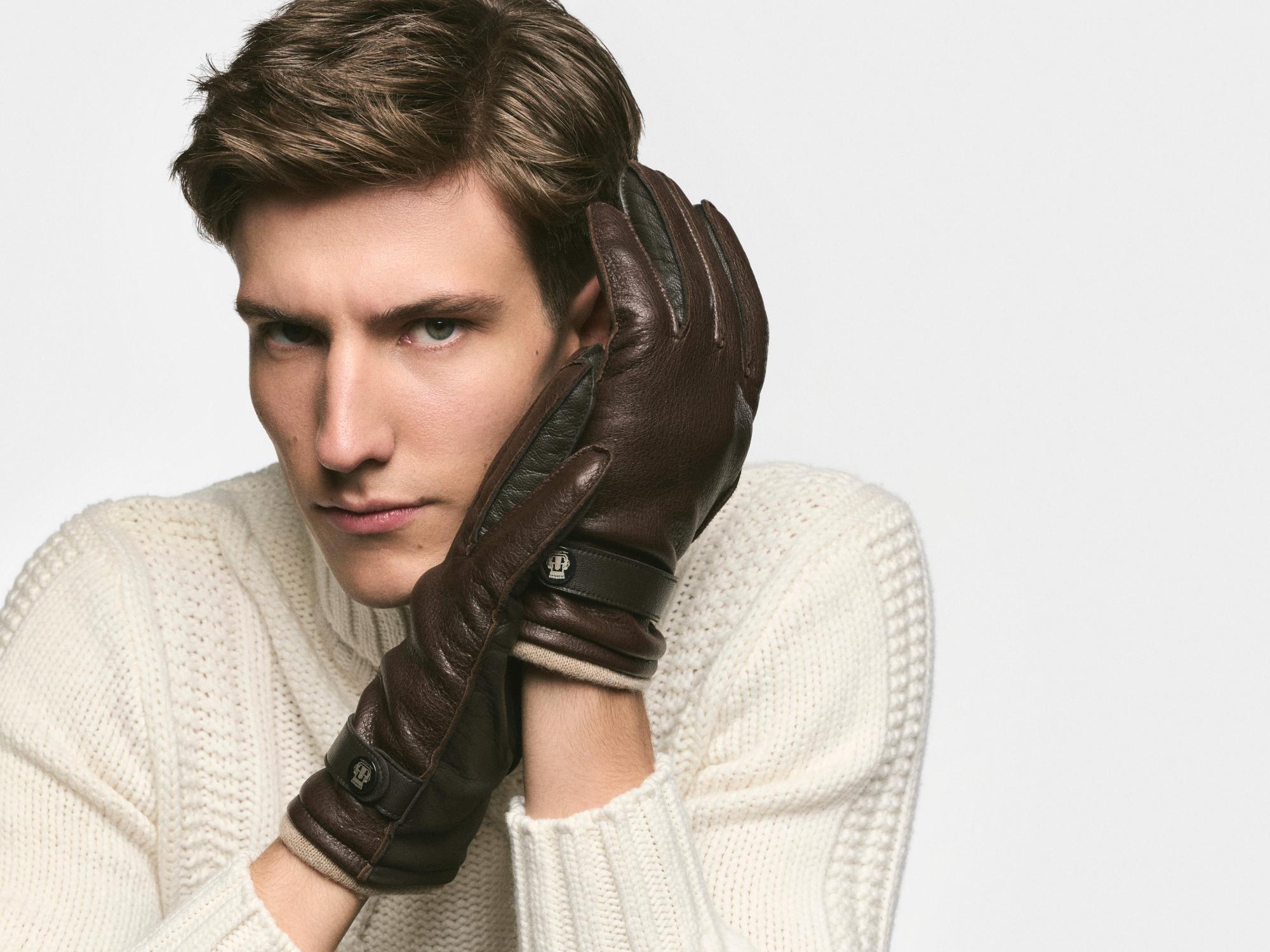 Mann mit braunen ROECKL-Lederhandschuhen – klassisches Accessoire aus feinstem Leder für stilvolle Herrenmode.