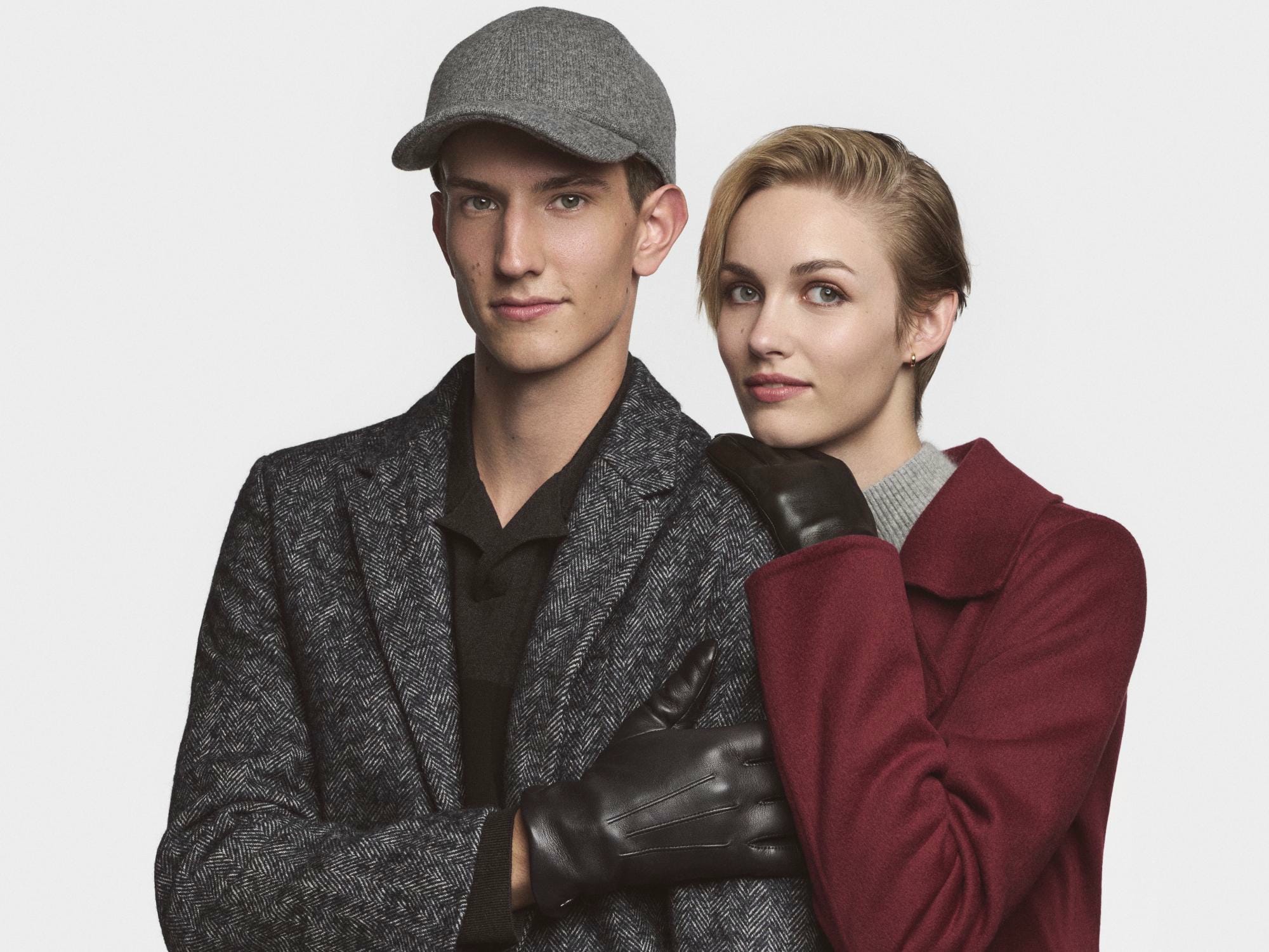 Eine blonde Dame trägt gehäkelte Handschuhe in beige und einen Strohhut.