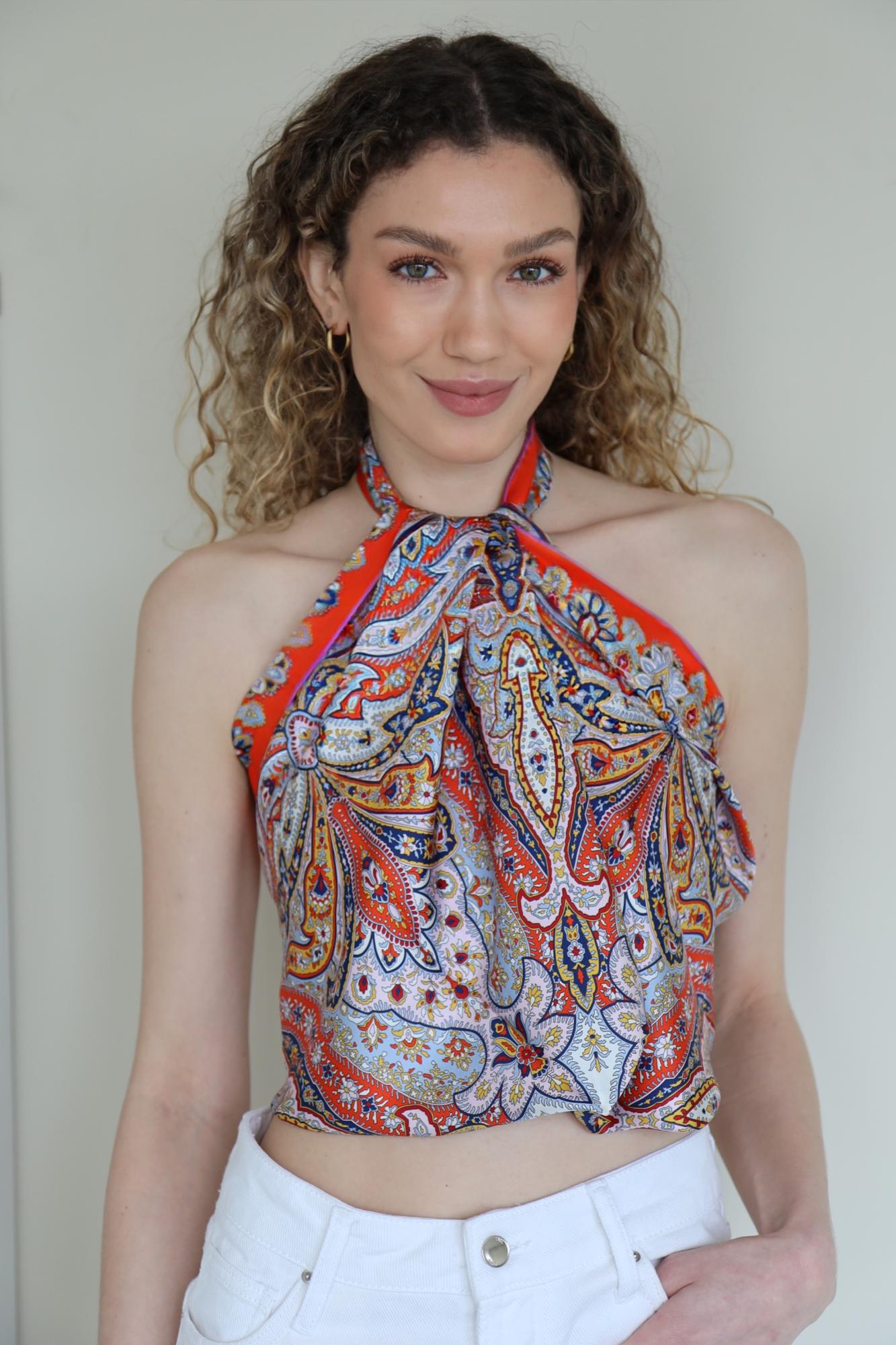 Frau mit cremefarbenem ROECKL-Seidentuch mit floralem Muster – elegantes Kopftuch als edles Mode-Statement zu beigefarbenem Mantel.