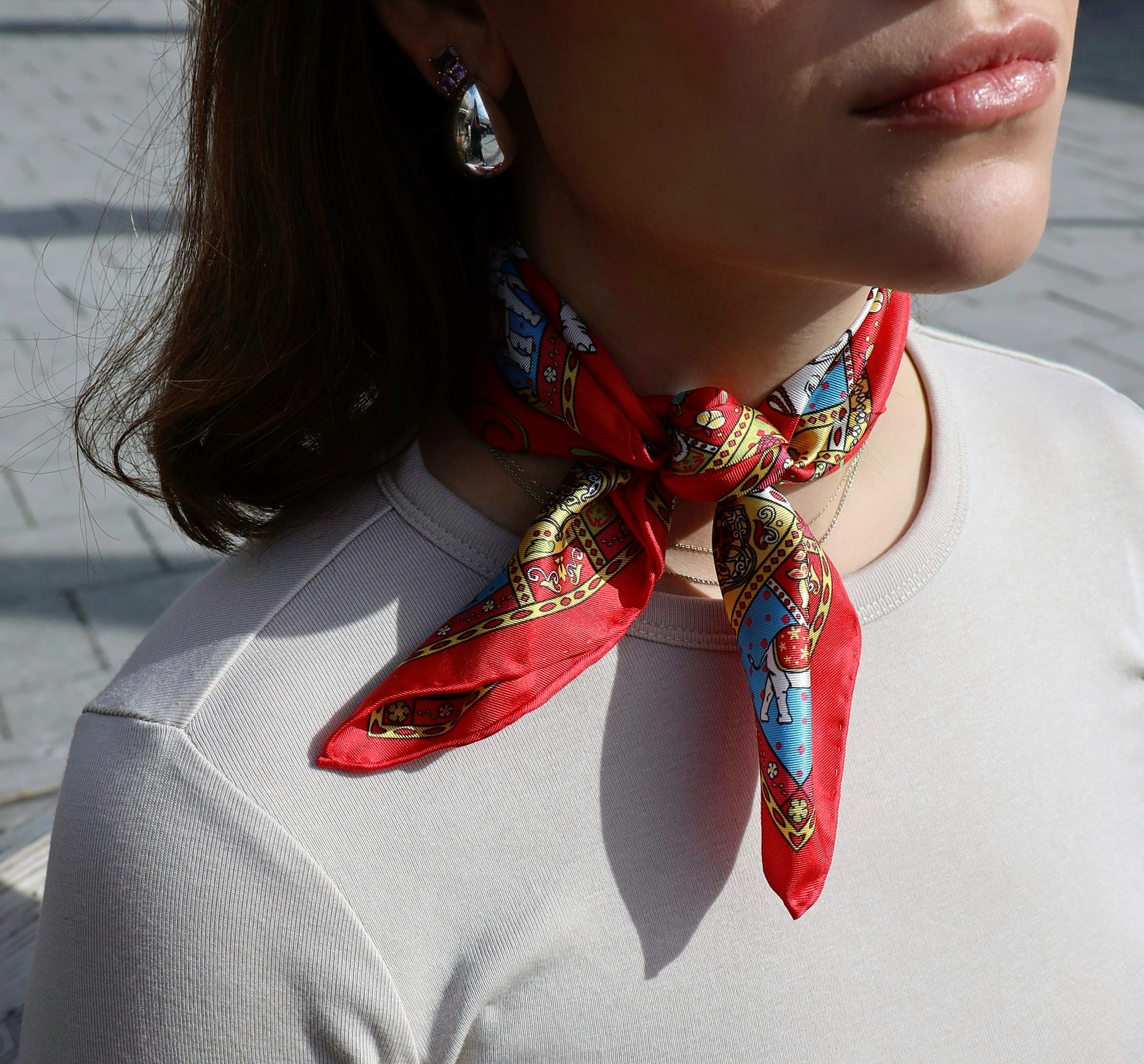 A red silk scarf tied around the neck as a neckerchief.