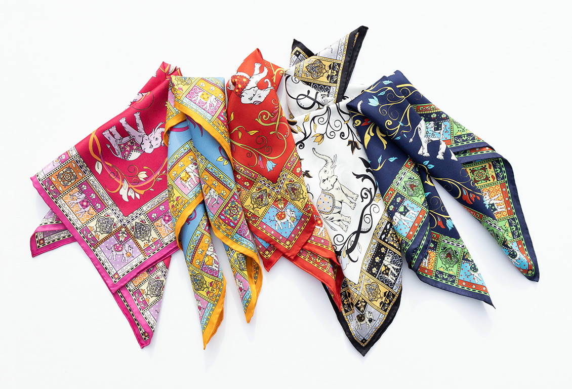 Farbintensive ROECKL-Seidentücher mit kunstvollen Mustern in Rot, Blau, Weiß und Gelb – hochwertige Accessoires aus feiner Seide.