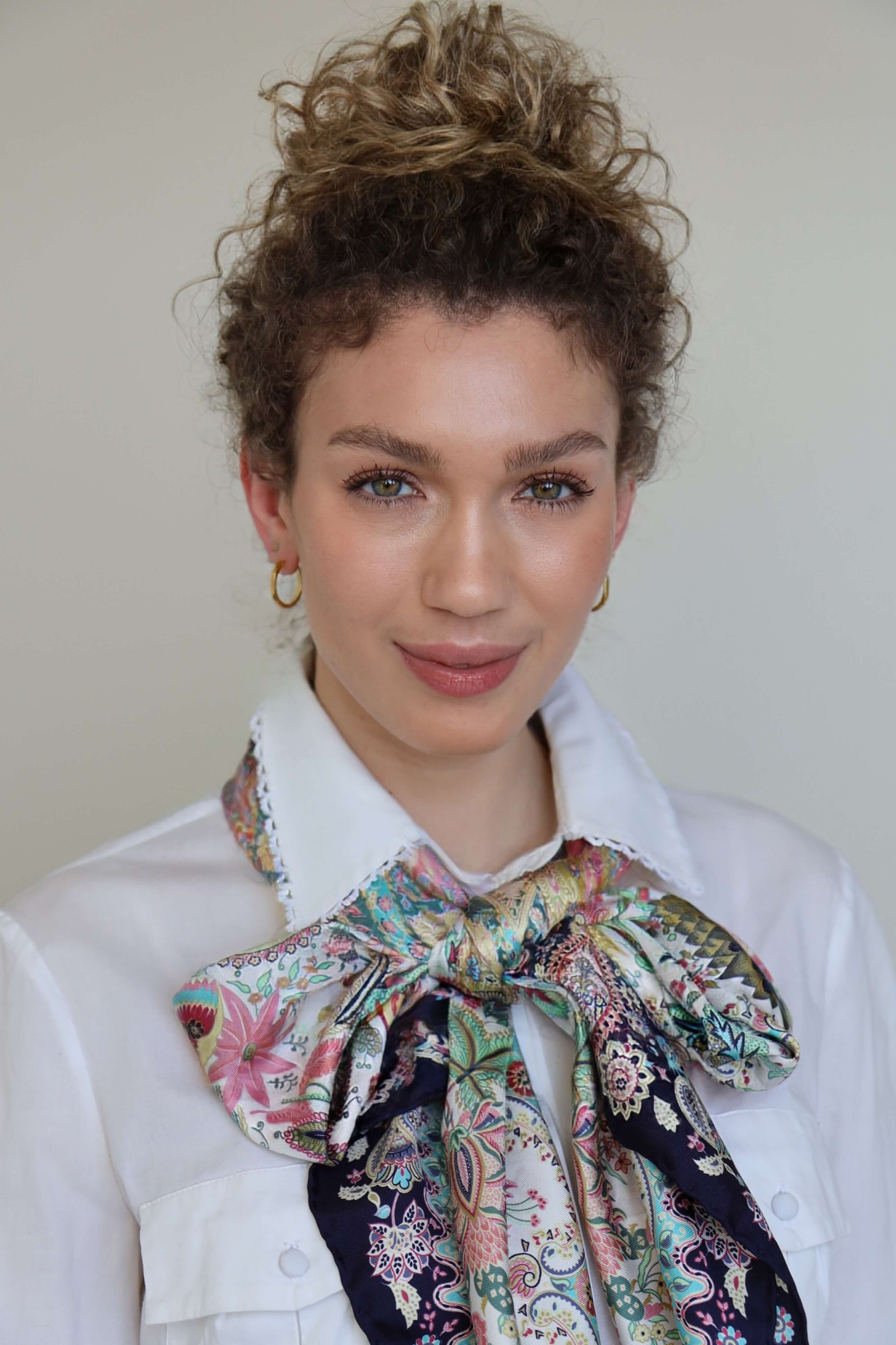 Ein Seidentuch als Schleife um den Hals gebunden verleiht jedem Look eine besonders feminine und stilvolle Note